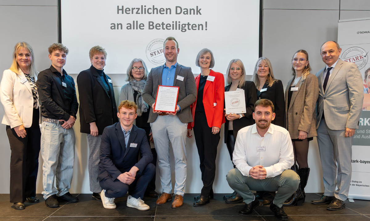 Personengruppe auf Bühne bei der Verleihung des STARK-Gütesiegels an das Berufliche Schulzentrum Sulzbach-Rosenberg, mit Schulleitung, Kollegium, Schülerinnen und Schülern, der STARK-Projektleiterin sowie Vertreterinnen und Vertretern der Regierung der Oberpfalz.