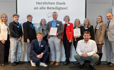 Personengruppe auf Bühne bei der Verleihung des STARK-Gütesiegels an das Berufliche Schulzentrum Sulzbach-Rosenberg, mit Schulleitung, Kollegium, Schülerinnen und Schülern, der STARK-Projektleiterin sowie Vertreterinnen und Vertretern der Regierung der Oberpfalz